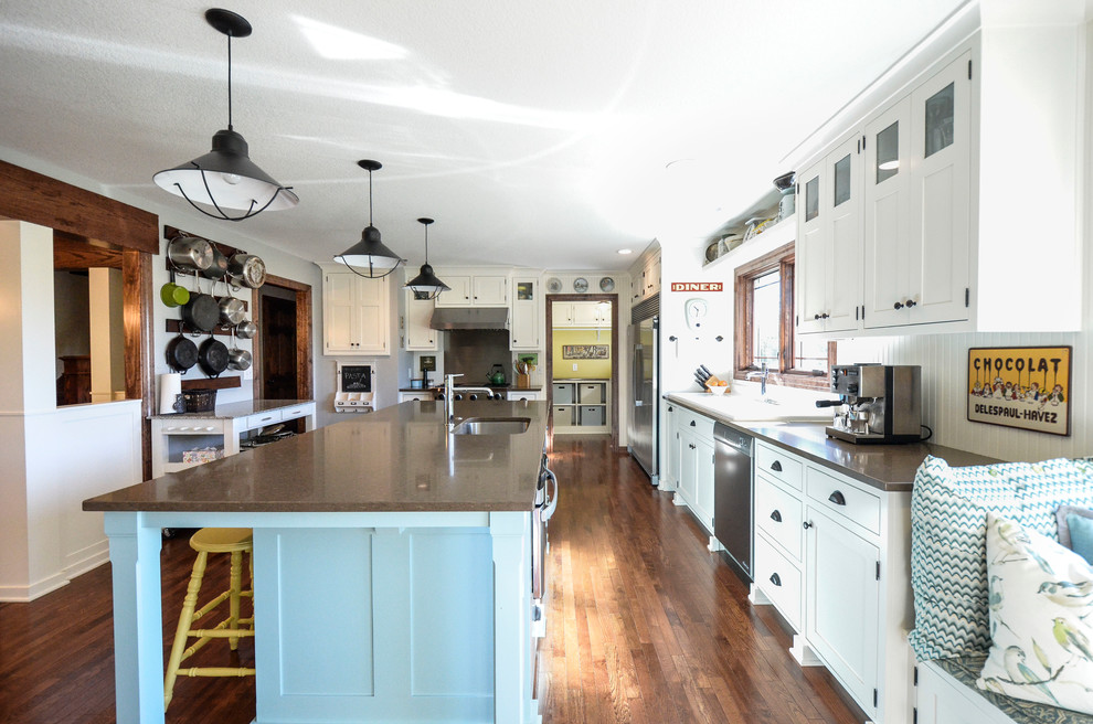 Large cottage l-shaped dark wood floor eat-in kitchen photo in Kansas City with a double-bowl sink, shaker cabinets, white cabinets, quartz countertops, white backsplash, stainless steel appliances and an island