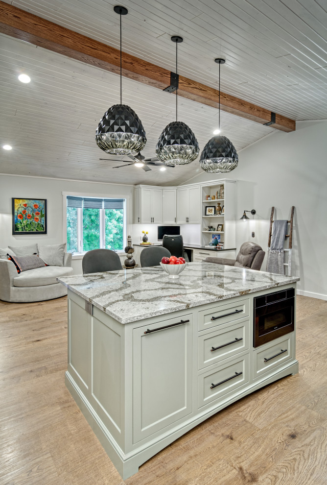 Eklektisk inredning av ett mellanstort grå grått kök, med en dubbel diskho, luckor med infälld panel, vita skåp, bänkskiva i kvartsit, vitt stänkskydd, stänkskydd i marmor, svarta vitvaror, vinylgolv, en köksö och brunt golv