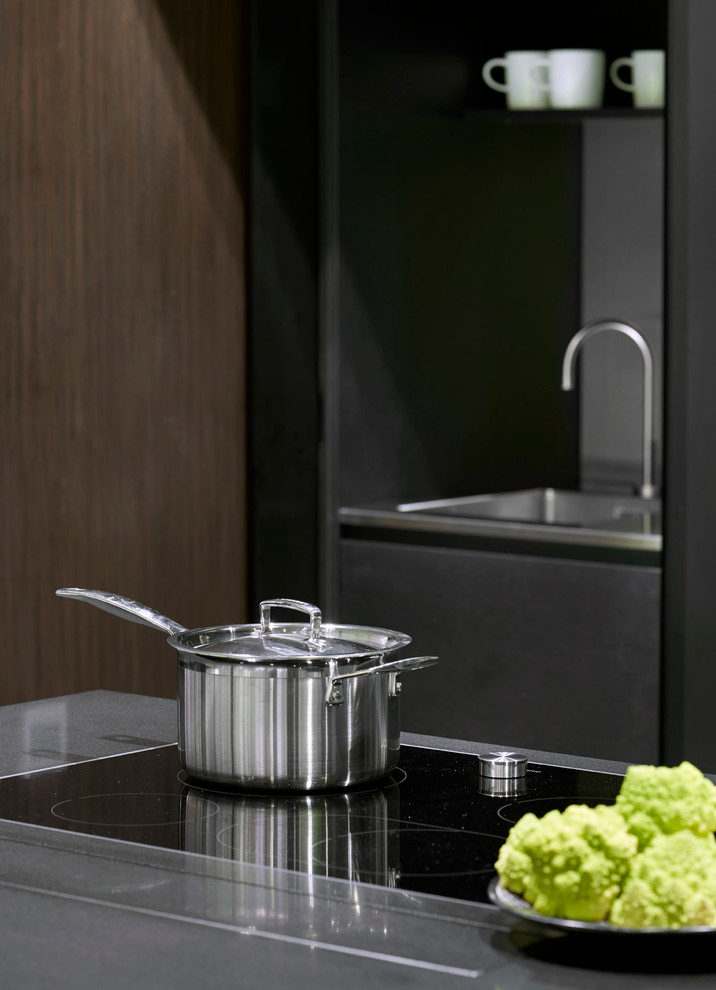 Esempio di una cucina minimal con lavello integrato, ante lisce, elettrodomestici da incasso e ante nere