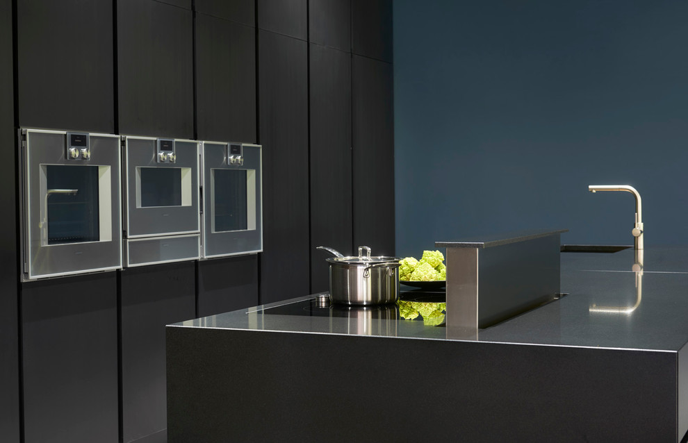Offene, Einzeilige Moderne Küche mit integriertem Waschbecken, flächenbündigen Schrankfronten, Elektrogeräten mit Frontblende, Kücheninsel und Granit-Arbeitsplatte in London