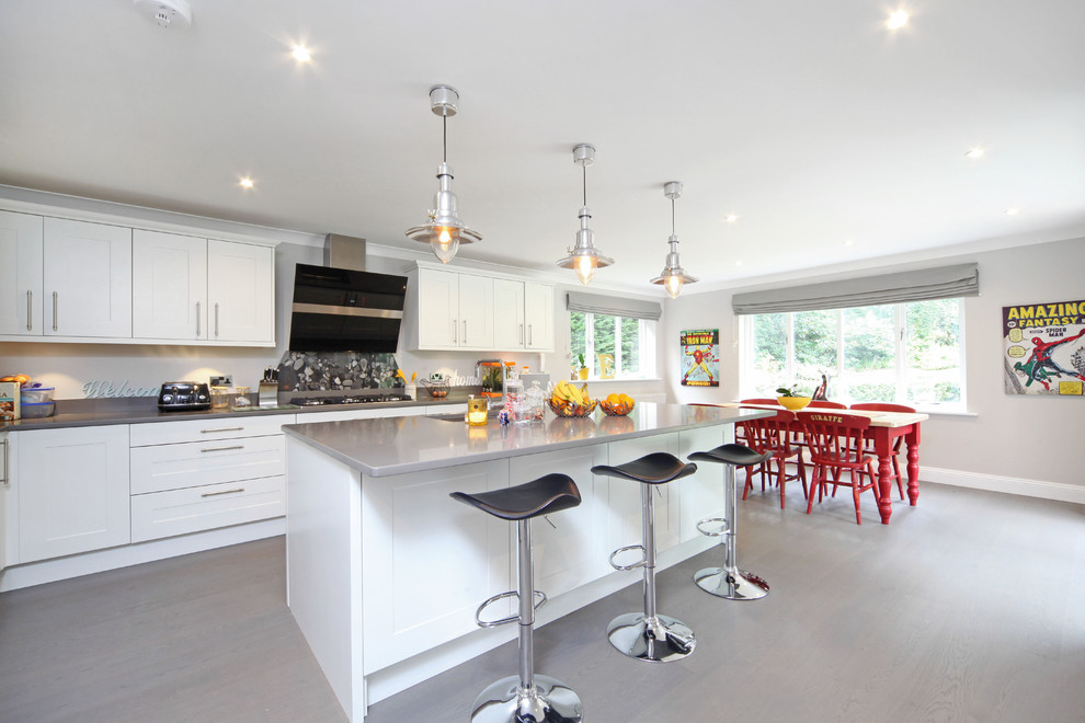 Design ideas for a contemporary l-shaped kitchen/diner in Berkshire with an island, shaker cabinets and white cabinets.