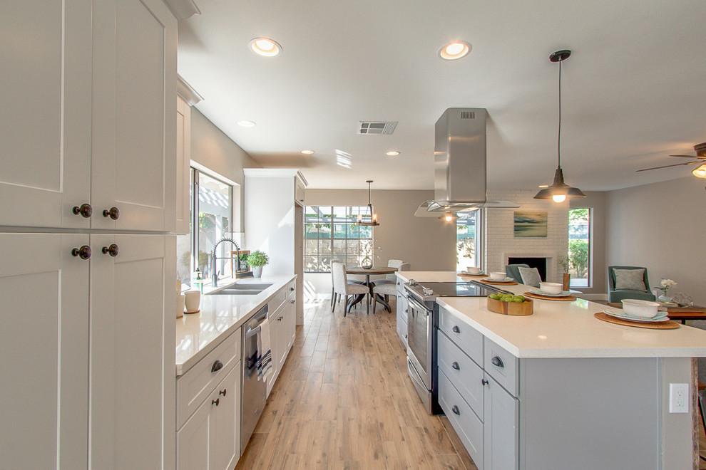 Inspiration for a medium sized classic open plan kitchen in Los Angeles with shaker cabinets, grey cabinets, quartz worktops, stainless steel appliances, medium hardwood flooring, an island and beige floors.