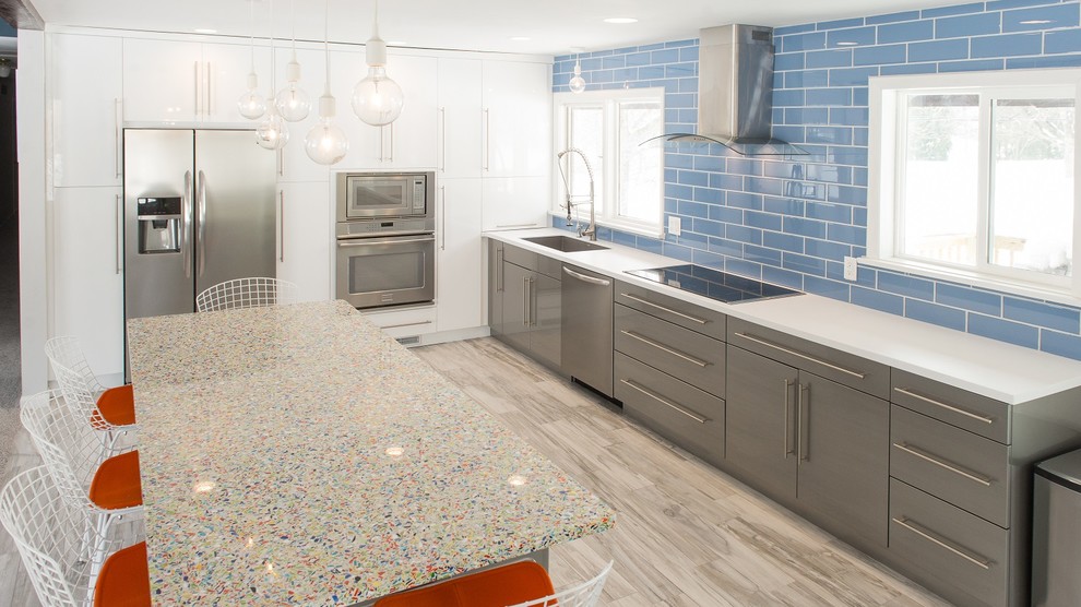 Mittelgroße Moderne Wohnküche in L-Form mit Waschbecken, Arbeitsplatte aus Recyclingglas, Küchenrückwand in Blau, Rückwand aus Glasfliesen, Küchengeräten aus Edelstahl, Keramikboden und Kücheninsel in Sonstige