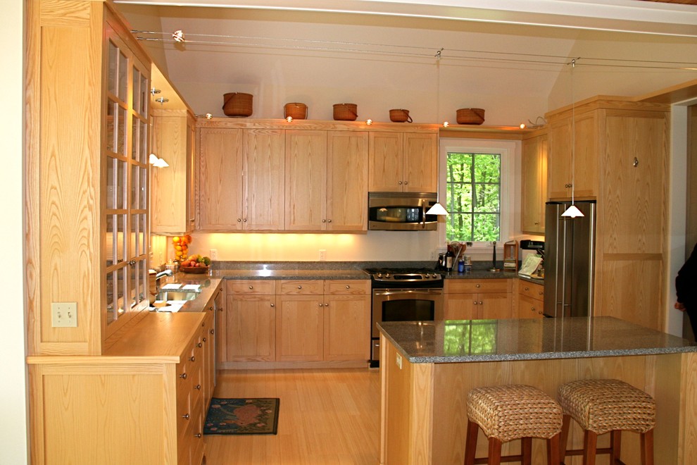 Пример оригинального дизайна: п-образная кухня в классическом стиле с обеденным столом, врезной мойкой, фасадами с утопленной филенкой, светлыми деревянными фасадами, столешницей из талькохлорита и техникой из нержавеющей стали