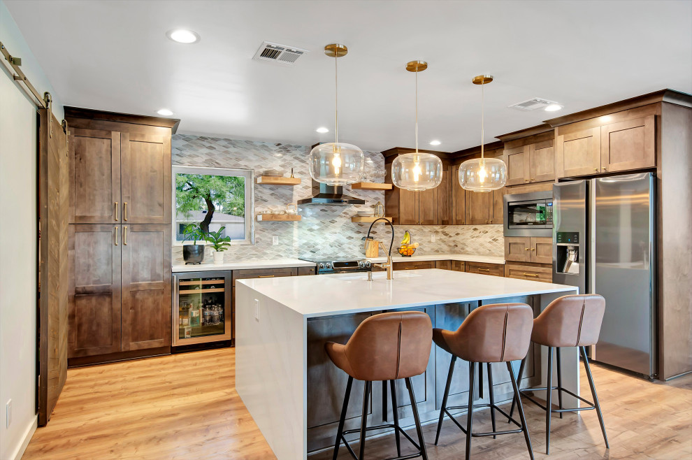 Example of a mid-sized transitional l-shaped medium tone wood floor and brown floor eat-in kitchen design in Phoenix with an undermount sink, shaker cabinets, medium tone wood cabinets, an island, multicolored backsplash, stainless steel appliances and white countertops
