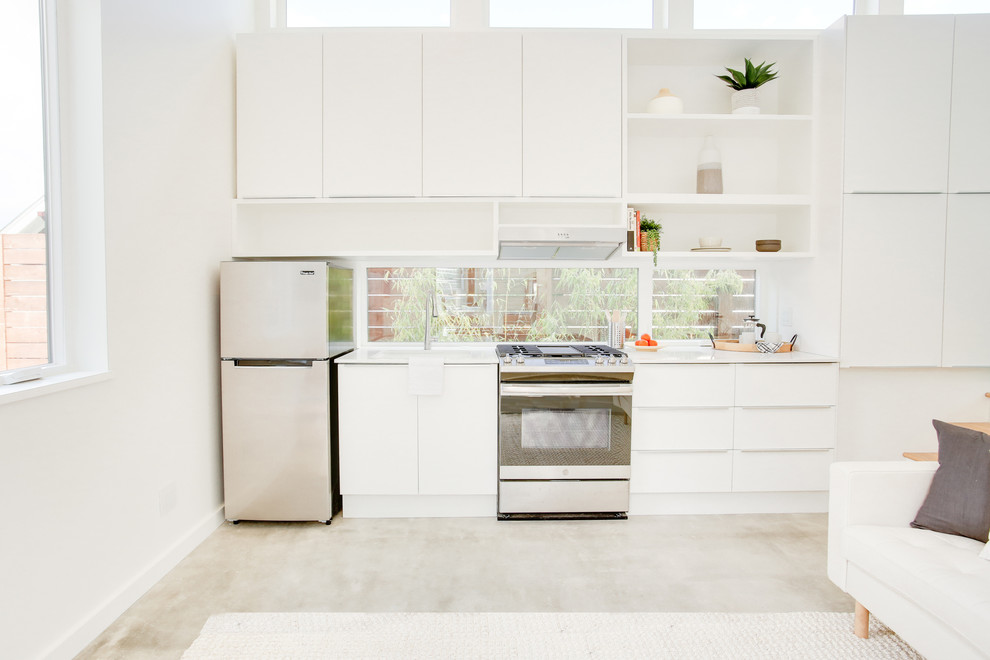 Foto di una piccola cucina nordica con lavello da incasso, ante lisce, ante bianche, top in quarzite, pavimento in cemento, pavimento grigio e top bianco