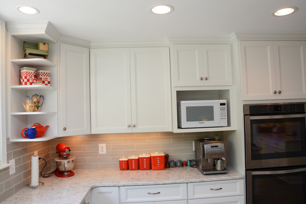 Klassisk inredning av ett avskilt, mellanstort vit vitt u-kök, med en enkel diskho, luckor med infälld panel, vita skåp, bänkskiva i kvarts, grått stänkskydd, rostfria vitvaror, en köksö och grått golv