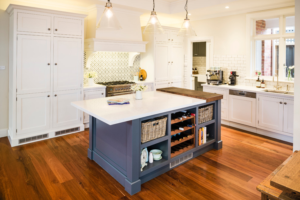 Traditional l-shaped kitchen in Melbourne with a double-bowl sink, shaker cabinets, white cabinets, beige splashback, metro tiled splashback and integrated appliances.