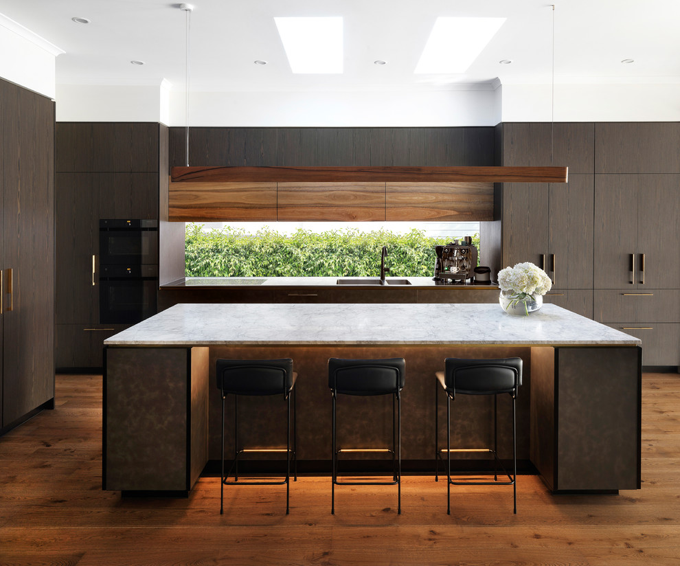 Inspiration for a contemporary l-shaped kitchen in Melbourne with an integrated sink, flat-panel cabinets, dark wood cabinets, window splashback, integrated appliances, medium hardwood flooring, an island, brown floors and grey worktops.
