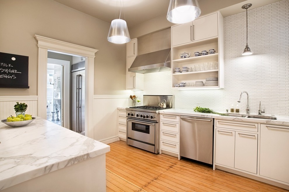 Exempel på ett avskilt, mellanstort modernt l-kök, med rostfria vitvaror, marmorbänkskiva, en dubbel diskho, öppna hyllor, vita skåp, vitt stänkskydd, stänkskydd i stickkakel, ljust trägolv, en köksö och brunt golv