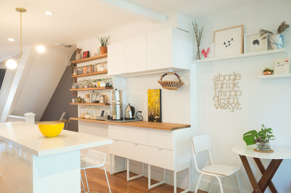 На фото: прямая кухня среднего размера в скандинавском стиле с обеденным столом, белыми фасадами, белым фартуком, светлым паркетным полом, островом и плоскими фасадами с