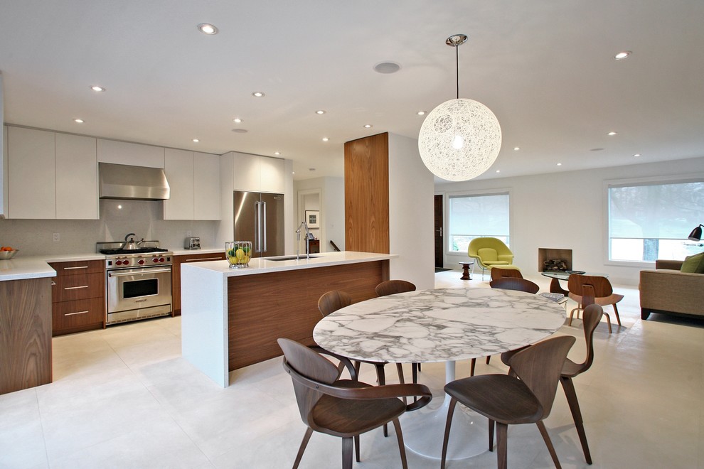 Example of a minimalist galley open concept kitchen design in Toronto with an undermount sink, dark wood cabinets, flat-panel cabinets, white backsplash and stainless steel appliances