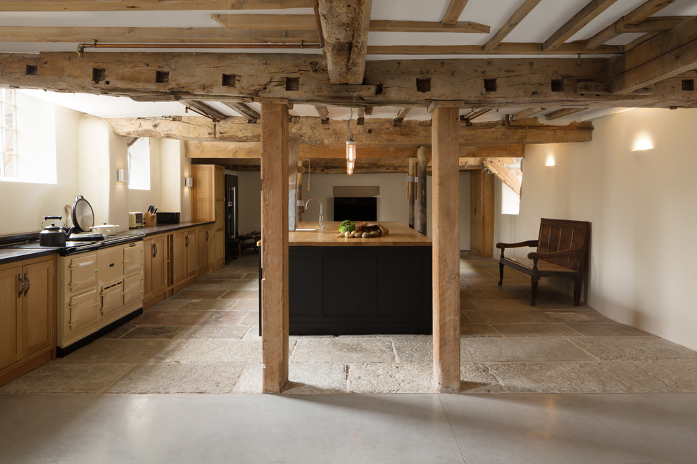 ロンドンにある広いカントリー風のおしゃれなキッチン (シェーカースタイル扉のキャビネット、淡色木目調キャビネット、木材カウンター、白い調理設備、ベージュの床、ベージュのキッチンカウンター) の写真