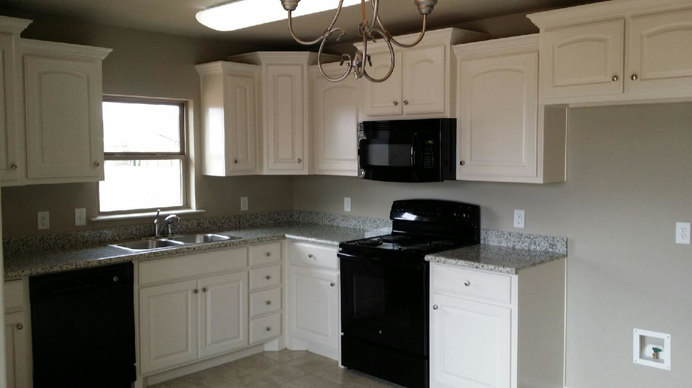 Exempel på ett klassiskt kök, med en dubbel diskho, luckor med upphöjd panel, vita skåp, granitbänkskiva, svarta vitvaror och klinkergolv i keramik