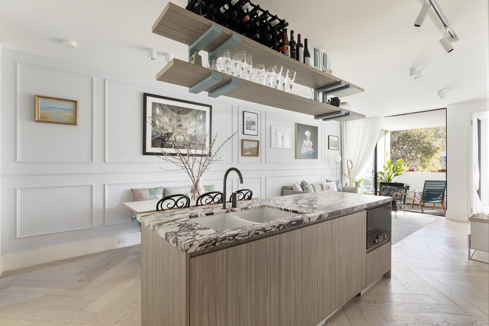 Modern inredning av ett litet lila lila kök, med en undermonterad diskho, skåp i ljust trä, marmorbänkskiva, flerfärgad stänkskydd, stänkskydd i marmor, svarta vitvaror, ljust trägolv, en köksö och beiget golv