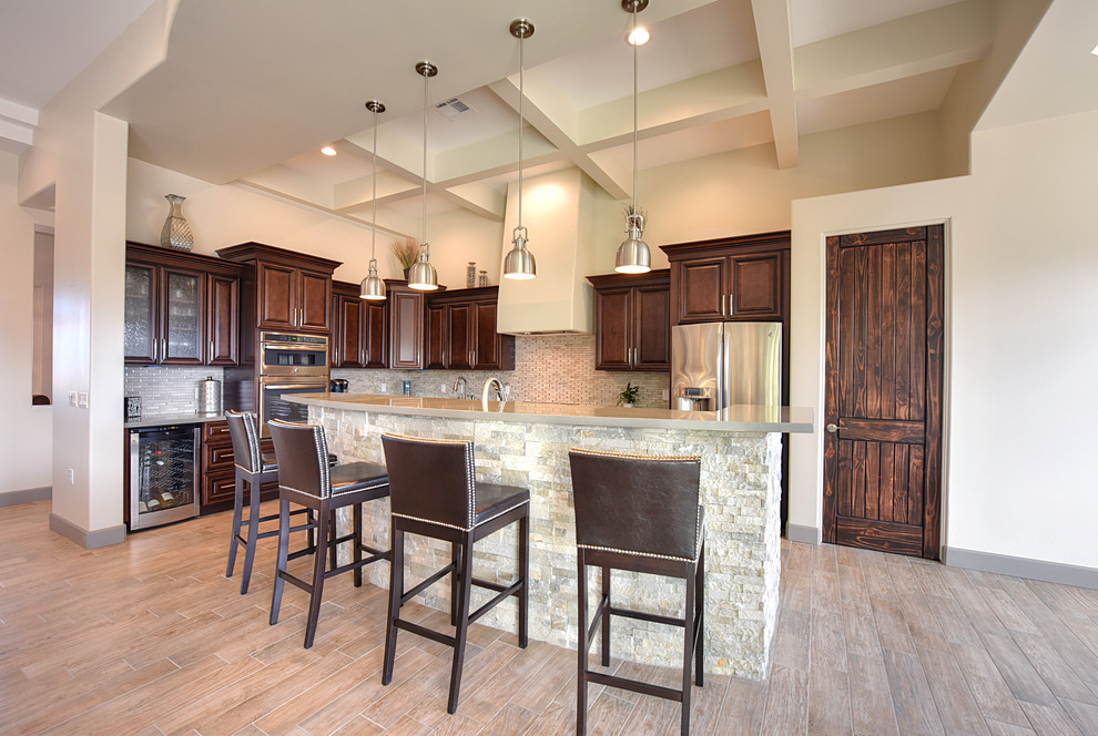 Mid-sized transitional l-shaped light wood floor open concept kitchen photo in Phoenix with raised-panel cabinets, medium tone wood cabinets, gray backsplash, stainless steel appliances and an island