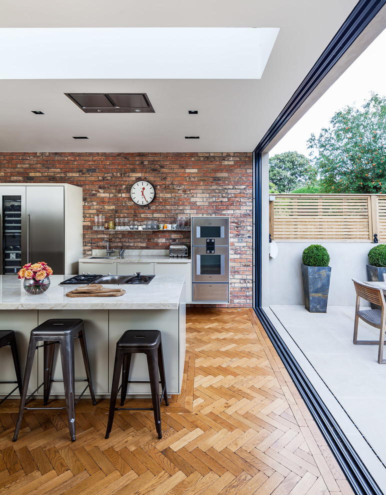 Moderne Küche mit flächenbündigen Schrankfronten und Küchengeräten aus Edelstahl in Surrey