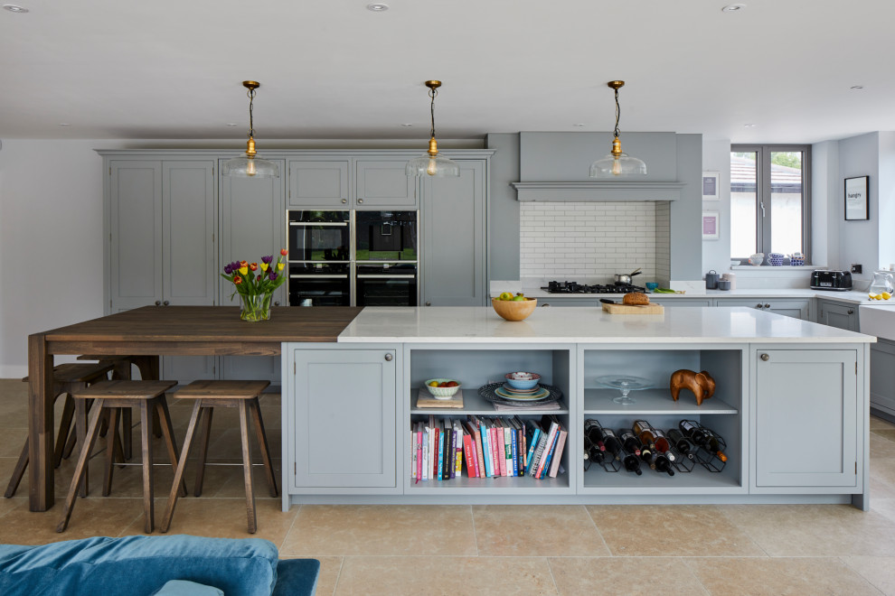 Photo of a large classic l-shaped open plan kitchen in Kent with a belfast sink, quartz worktops and an island.