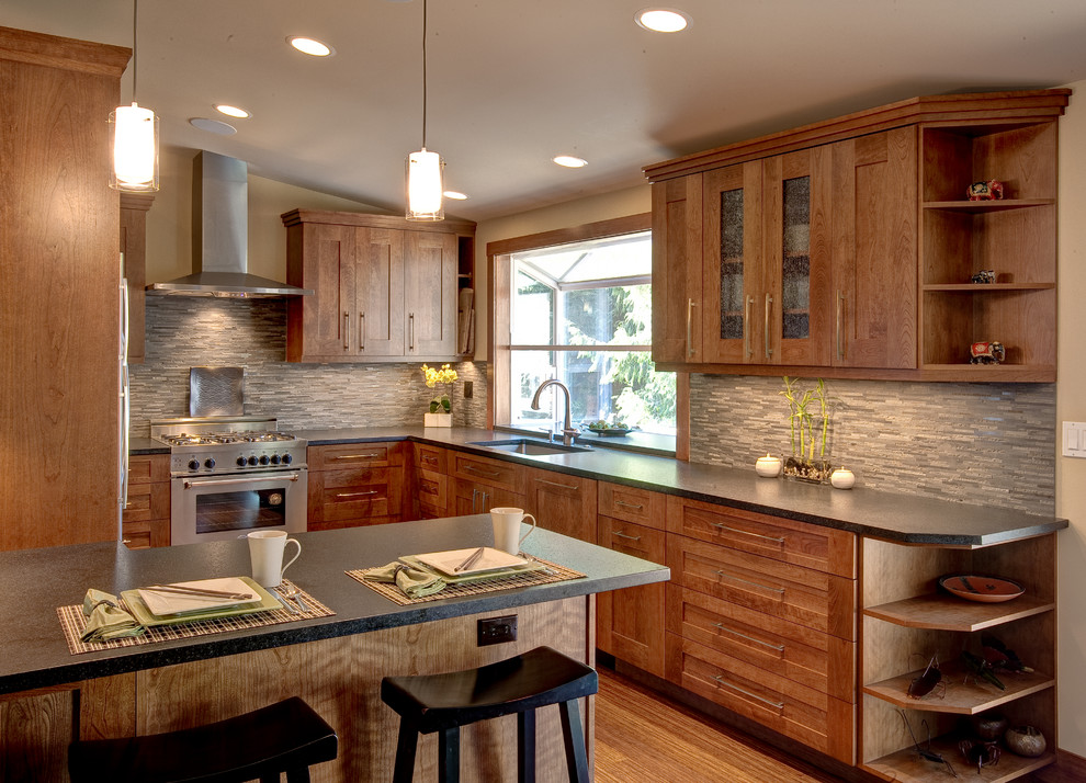 Mid-sized zen u-shaped light wood floor and beige floor kitchen photo in Seattle with an undermount sink, shaker cabinets, medium tone wood cabinets, solid surface countertops, gray backsplash, matchstick tile backsplash, stainless steel appliances and a peninsula