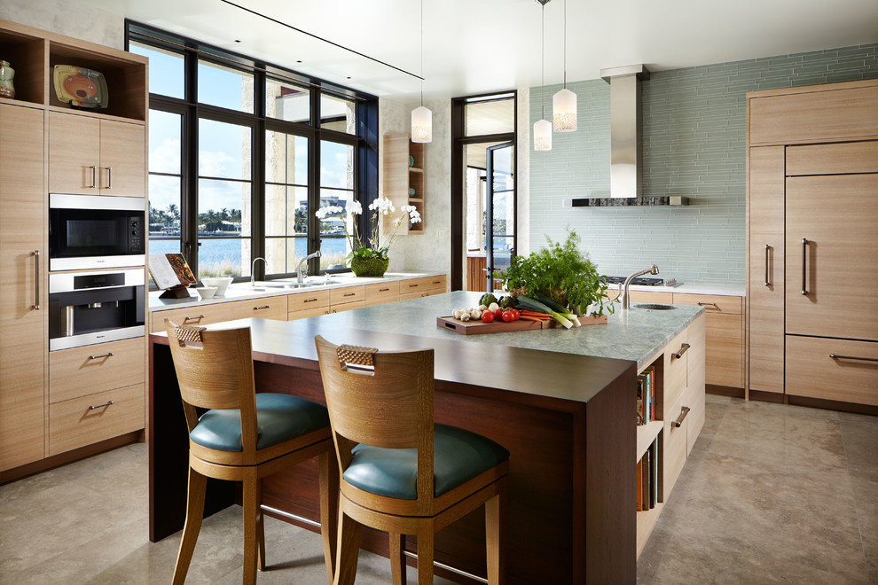 Eat-in kitchen - large zen l-shaped concrete floor and brown floor eat-in kitchen idea in Wichita with an undermount sink, flat-panel cabinets, light wood cabinets, stainless steel appliances, an island, granite countertops, blue backsplash and subway tile backsplash