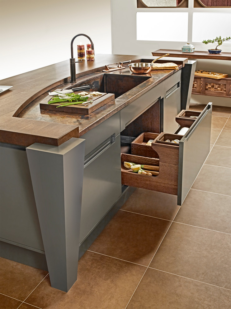 World-inspired u-shaped kitchen/diner in Other with an integrated sink, wood worktops, green splashback, stone slab splashback and grey cabinets.