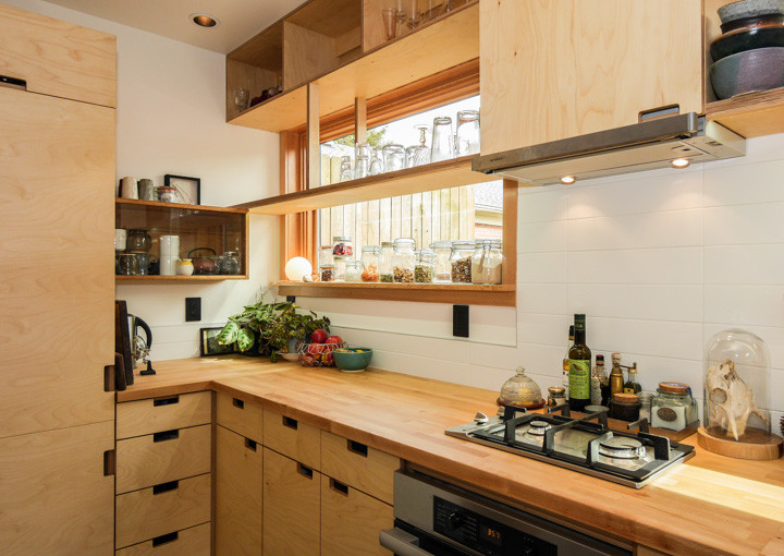 Diseño de cocina de estilo zen con armarios con paneles lisos, puertas de armario de madera clara, encimera de madera, salpicadero blanco y salpicadero de azulejos de cerámica