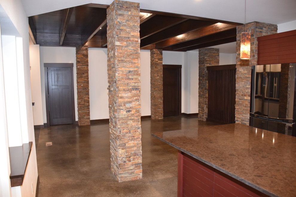 Klassisk inredning av ett mellanstort linjärt kök och matrum, med en enkel diskho, släta luckor, röda skåp, bänkskiva i kvarts, flerfärgad stänkskydd, glaspanel som stänkskydd, rostfria vitvaror, betonggolv, en köksö och brunt golv