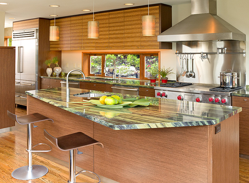 Example of a trendy kitchen design in Seattle with flat-panel cabinets, medium tone wood cabinets, stainless steel appliances, an island and green countertops