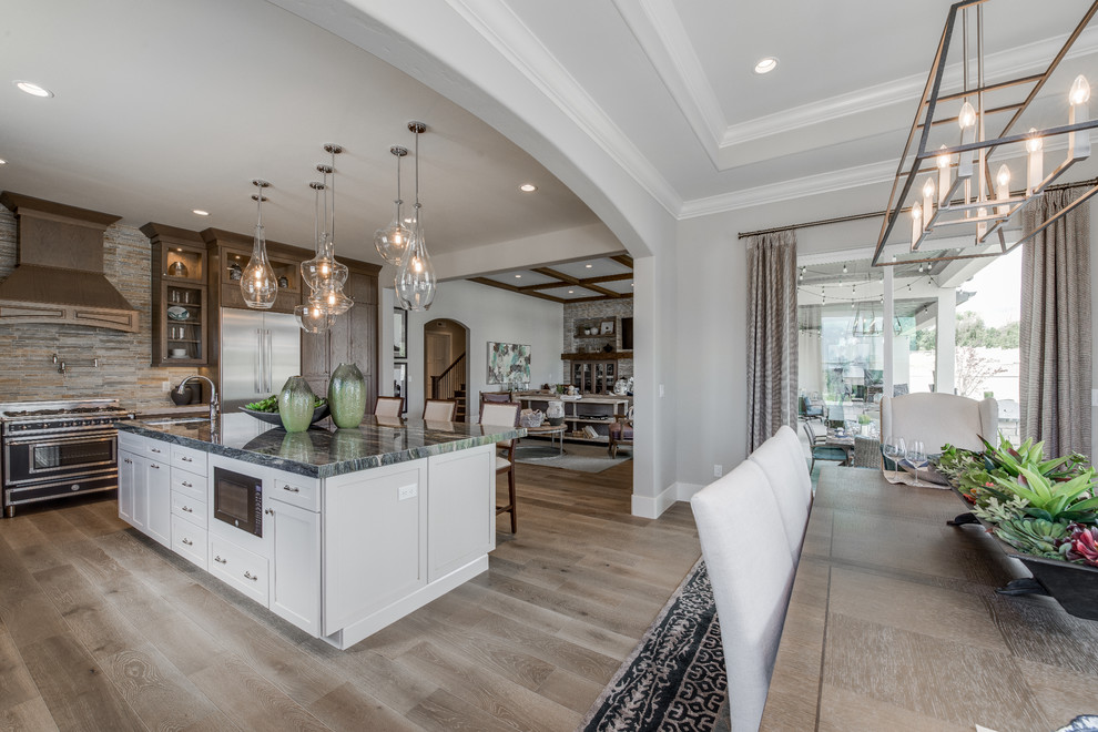 Inspiration for a large timeless light wood floor and brown floor eat-in kitchen remodel in Salt Lake City with an undermount sink, recessed-panel cabinets, dark wood cabinets, granite countertops, gray backsplash, ceramic backsplash, stainless steel appliances and an island