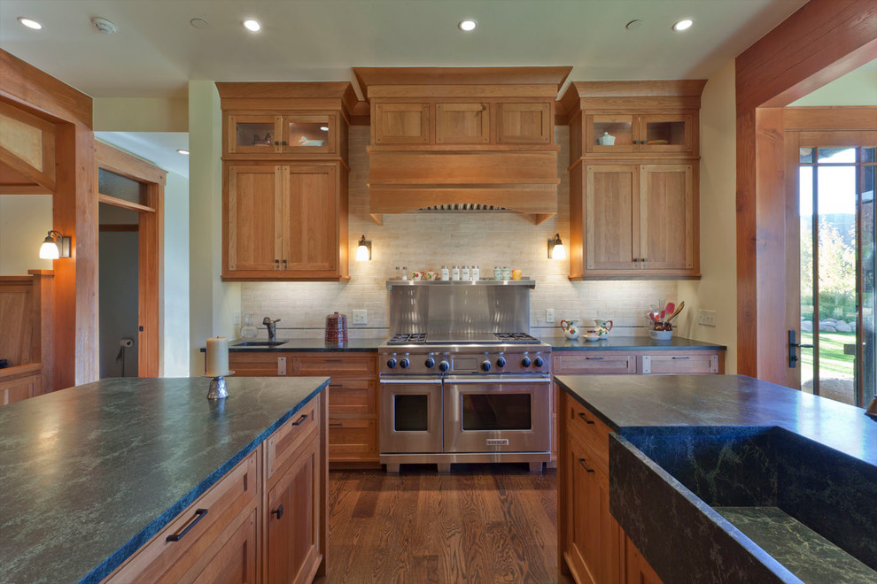 Foto de cocina clásica con fregadero integrado, armarios estilo shaker, puertas de armario de madera oscura, salpicadero beige, electrodomésticos de acero inoxidable y encimeras verdes