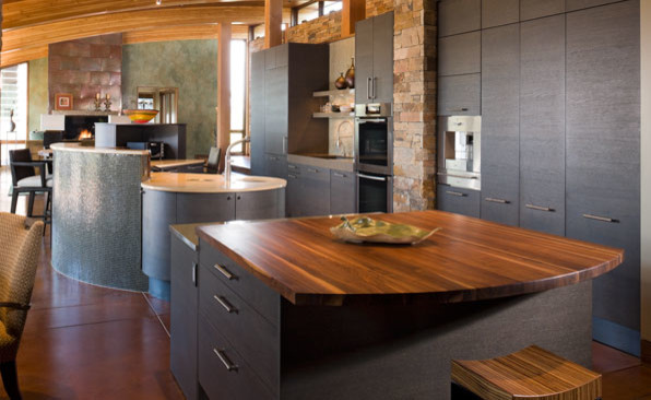 Cette photo montre une cuisine encastrable tendance en bois foncé avec un évier encastré, un placard à porte plane et un plan de travail en bois.