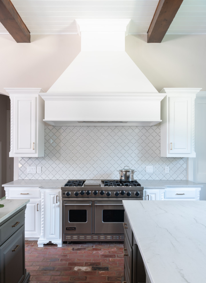 Inspiration for a transitional brick floor kitchen remodel in Dallas with raised-panel cabinets, white cabinets, white backsplash, stainless steel appliances, two islands and white countertops