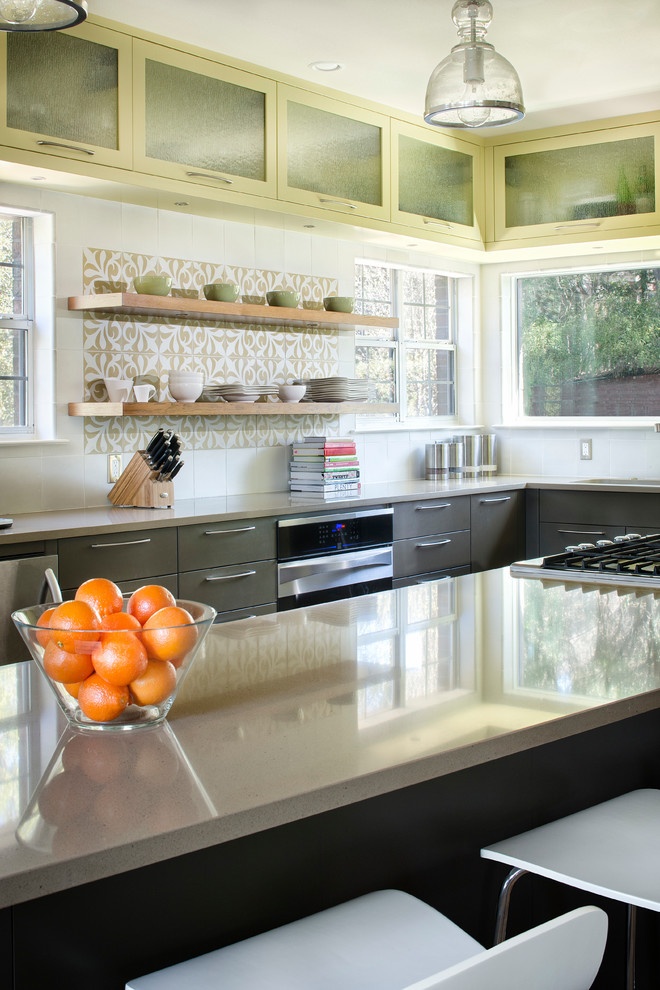 Foto de cocina comedor actual con puertas de armario grises, encimera de acrílico, suelo de madera en tonos medios y una isla