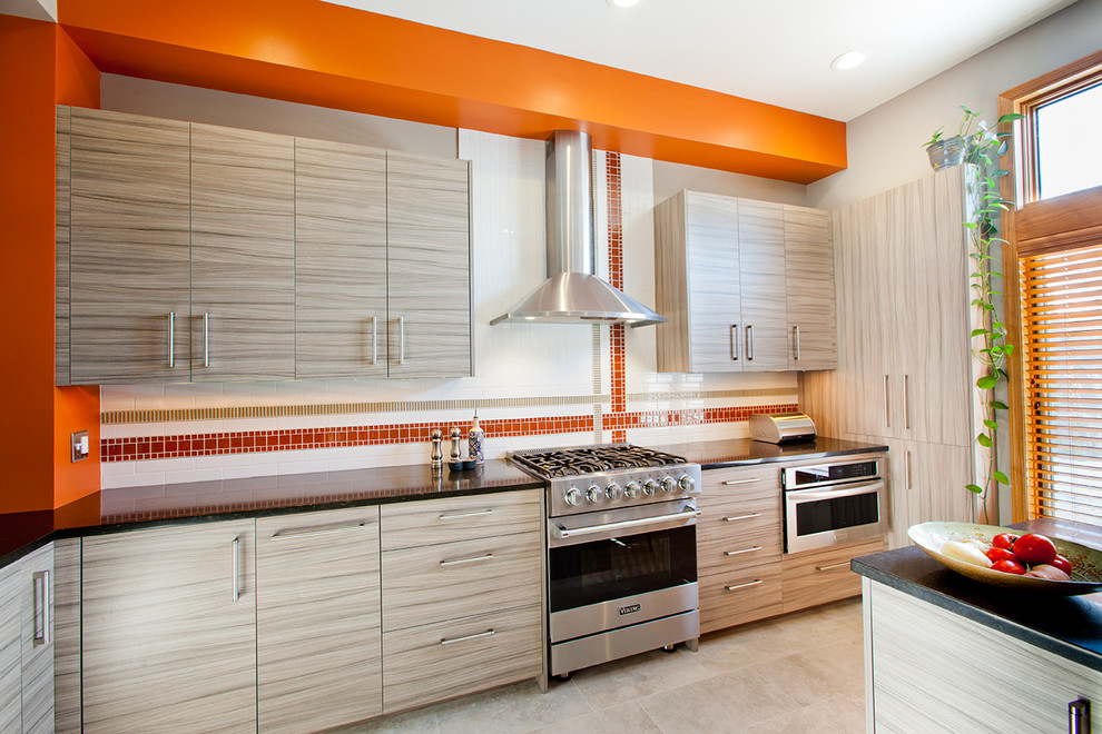 Diseño de cocina contemporánea con armarios con paneles lisos, puertas de armario grises, encimera de granito, salpicadero naranja, salpicadero de azulejos de cemento, electrodomésticos de acero inoxidable y península