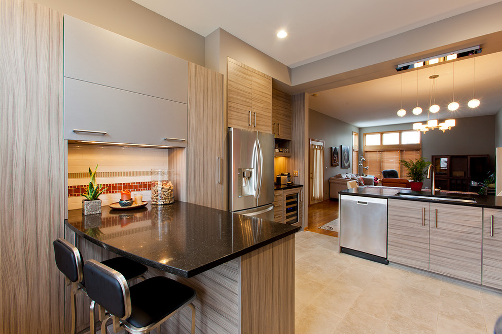 Example of a trendy beige floor kitchen design in Minneapolis with a peninsula, flat-panel cabinets, gray cabinets, granite countertops, orange backsplash, stainless steel appliances and ceramic backsplash