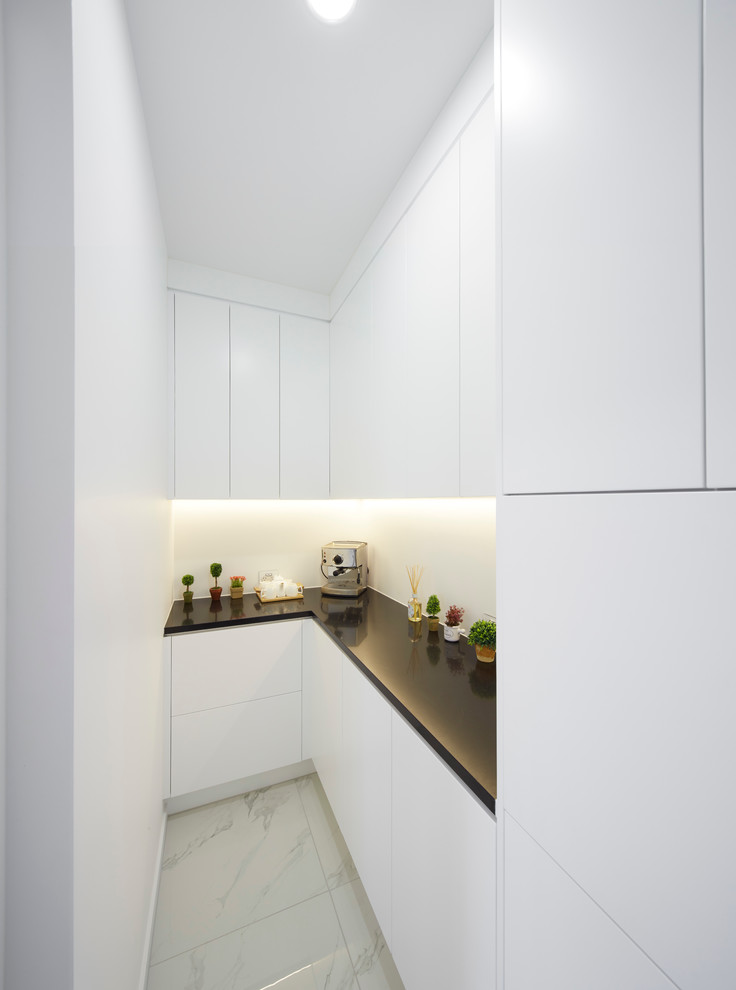 Cette photo montre une arrière-cuisine moderne avec des portes de placard blanches, une crédence grise, une crédence en feuille de verre, un électroménager en acier inoxydable, un sol en carrelage de céramique et îlot.