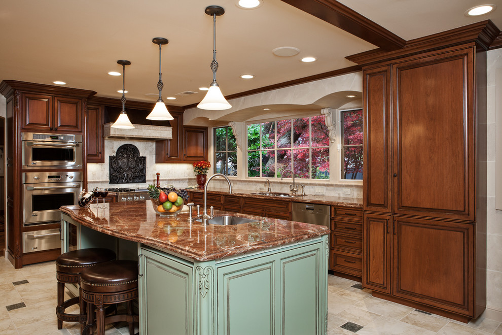 Example of a large classic l-shaped ceramic tile eat-in kitchen design in San Francisco with an undermount sink, raised-panel cabinets, medium tone wood cabinets, granite countertops, beige backsplash, ceramic backsplash, paneled appliances and an island