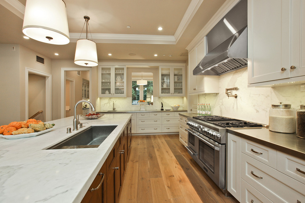 サンフランシスコにあるトランジショナルスタイルのおしゃれなキッチン (アンダーカウンターシンク、落し込みパネル扉のキャビネット、白いキャビネット、白いキッチンパネル、シルバーの調理設備) の写真