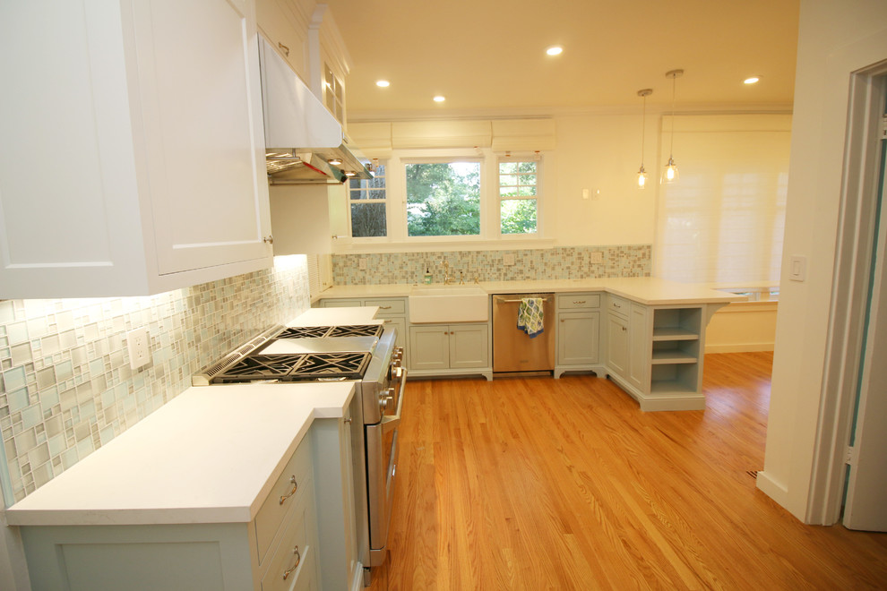 Idéer för mellanstora lantliga kök, med en rustik diskho, luckor med infälld panel, vita skåp, bänkskiva i kvarts, blått stänkskydd, stänkskydd i glaskakel, rostfria vitvaror, ljust trägolv och gult golv