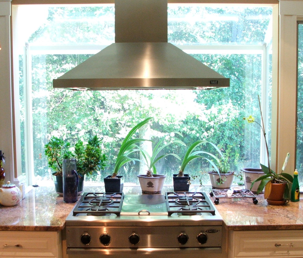 Inredning av ett medelhavsstil stort kök, med en undermonterad diskho, luckor med upphöjd panel, vita skåp, granitbänkskiva, rostfria vitvaror, klinkergolv i porslin, en köksö och beiget golv