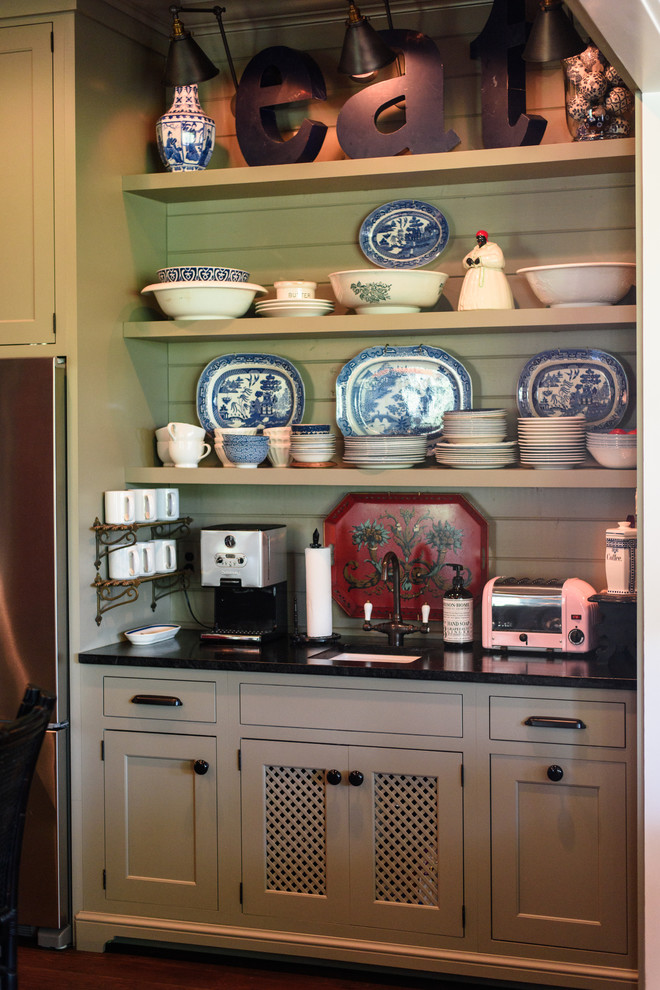 Inspiration for an eclectic dark wood floor kitchen remodel in Nashville with a farmhouse sink, shaker cabinets, green cabinets, soapstone countertops and an island