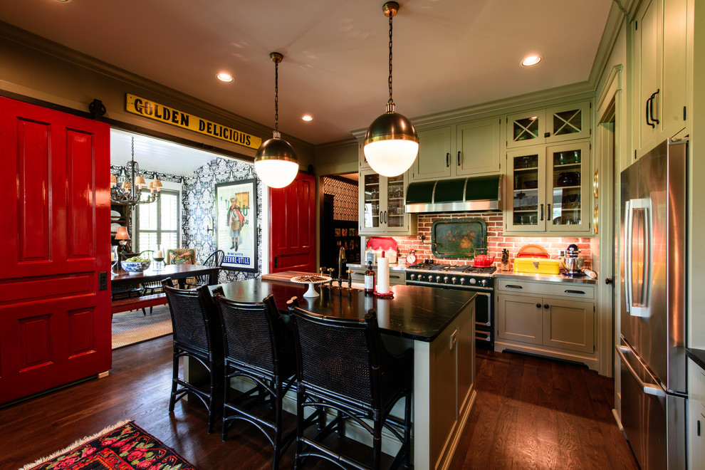 This is an example of an eclectic kitchen in Nashville with a belfast sink, shaker cabinets, green cabinets, soapstone worktops, dark hardwood flooring and an island.