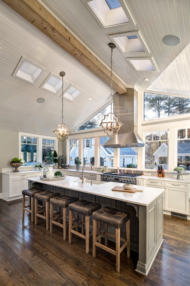 Kitchen - traditional l-shaped medium tone wood floor and brown floor kitchen idea in Other with a farmhouse sink, shaker cabinets, marble countertops, white backsplash, ceramic backsplash, stainless steel appliances and an island