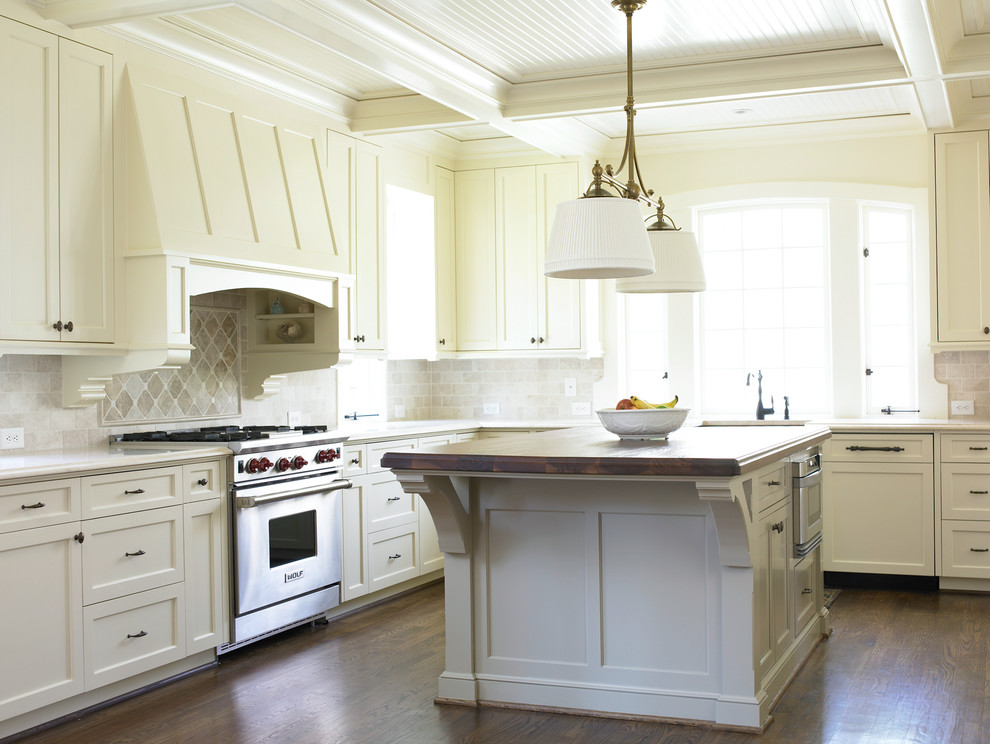 Immagine di una cucina a L classica con ante in stile shaker, ante bianche, paraspruzzi beige e elettrodomestici da incasso
