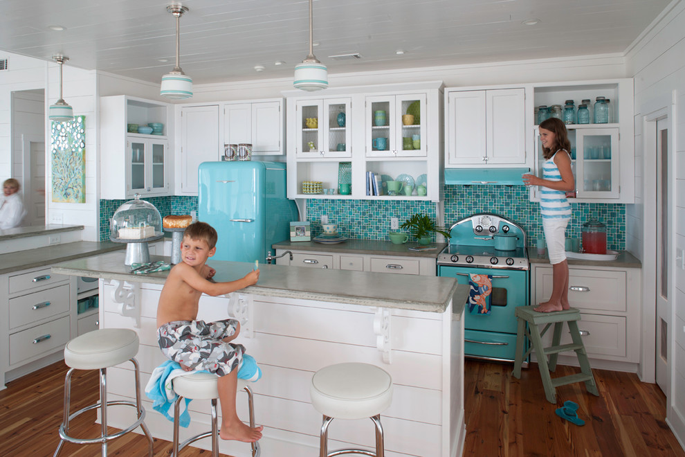 Maritime Küche in L-Form mit flächenbündigen Schrankfronten, weißen Schränken, Küchenrückwand in Blau, Rückwand aus Mosaikfliesen, bunten Elektrogeräten, braunem Holzboden und Kücheninsel in Atlanta