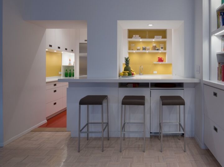 Bild på ett avskilt, litet funkis u-kök, med släta luckor, vita skåp, bänkskiva i koppar, en halv köksö, en undermonterad diskho, gult stänkskydd, glaspanel som stänkskydd, rostfria vitvaror, linoleumgolv och rött golv