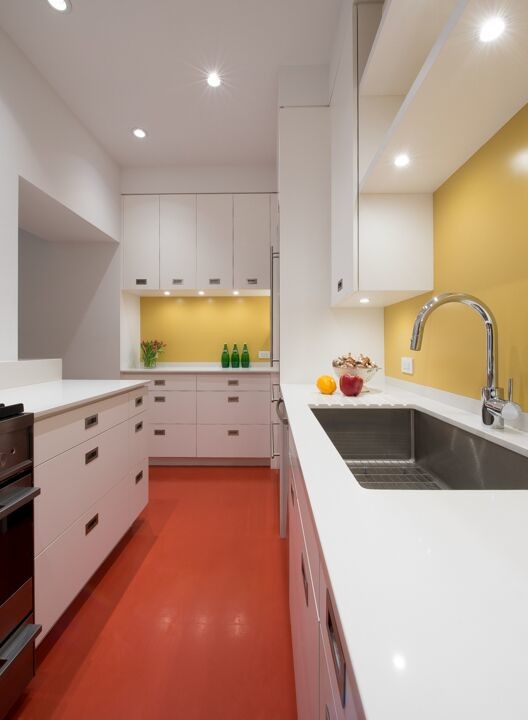 Inspiration för avskilda, små moderna u-kök, med en undermonterad diskho, släta luckor, vita skåp, bänkskiva i koppar, gult stänkskydd, glaspanel som stänkskydd, rostfria vitvaror, linoleumgolv, en halv köksö och rött golv