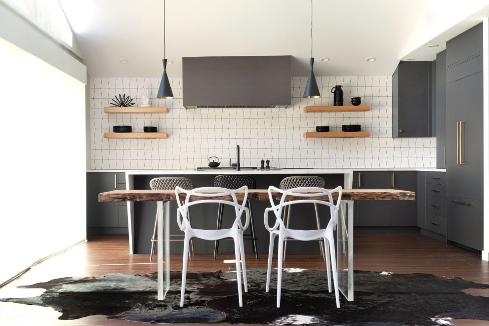 Пример оригинального дизайна: кухня в стиле ретро с обеденным столом, плоскими фасадами, черными фасадами, мраморной столешницей, фартуком из керамической плитки, темным паркетным полом и белой столешницей