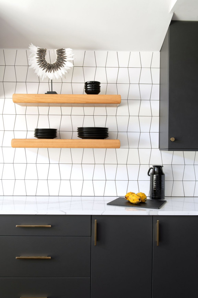 Ispirazione per una cucina abitabile moderna con ante lisce, ante nere, top in marmo, paraspruzzi con piastrelle in ceramica, parquet scuro e top bianco