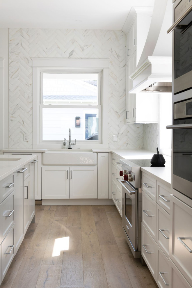 Foto de cocina lineal tradicional renovada con armarios con paneles con relieve, salpicadero blanco y salpicadero de mármol